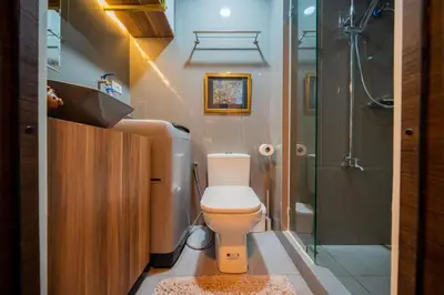 a bathroom with a toilet and a shower at House of Tulips in Air Residences Makati City in Manila