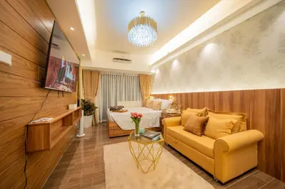 a hotel room with a couch and a bed at House of Tulips in Air Residences Makati City in Manila