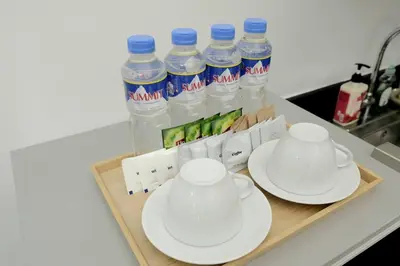 a tray with two cups and plates and bottles of water at WORLD TRADE CENTER 959 DYNASTEL SHORE Staycation in Manila