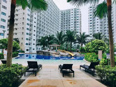 a pool with chairs and a water slide in a city at NAIA Pasay MOA 1250 Dynastel Shore Staycation in Manila