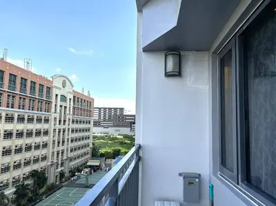 a balcony with a view of a city with buildings at DYNASTEL SHORE 635 MOA Pasay Staycation in Manila