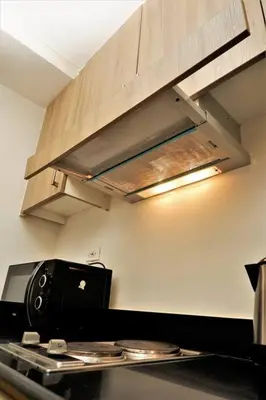 a kitchen with a stove top oven and a hood at SHORE RESIDENCES HOTEL Staycation 621 Dynastel in Manila