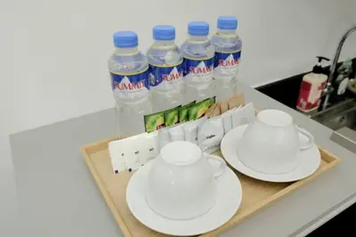 a tray with two cups and plates and bottles of water at SHORE RESIDENCES HOTEL Staycation 621 Dynastel in Manila