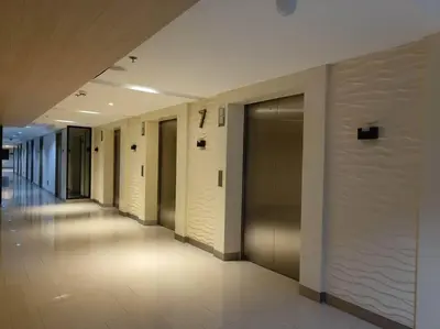a hallway of a building with doors and a hallwayngthngthngthngth at MALL OF ASIA 774 DYNASTEL SHORE Staycation in Manila