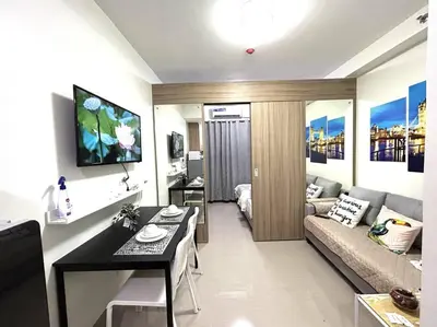 a living room with a couch and a table in a room at MOA PASAY 1478 Dynastel Shore Staycation in Manila