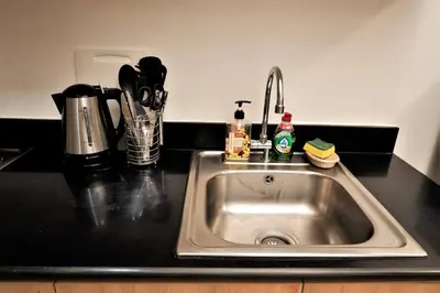 a stainless steel sink in a kitchen with a counter top at Shore Residences 1576 Dynastel Staycation in Manila
