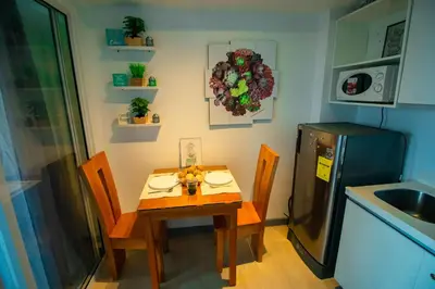 a small kitchen with a table and a refrigerator at Cozy Chic Condotel Azure Urban Resort Residences in Manila