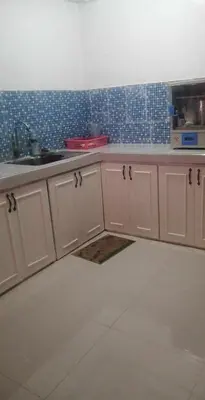 a kitchen with white cabinets and blue tiles on the wall at 4jMarte Home Stay in Imus