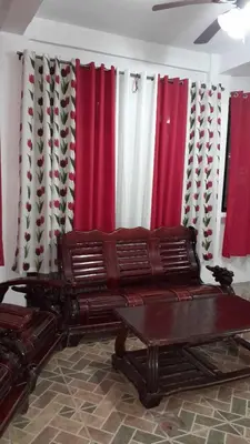 a living room with a couch and red and white curtains at 4jMarte Home Stay in Imus
