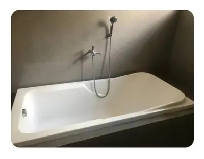 a white bath tub with a shower head in a bathroom at Kame House in Bacoor