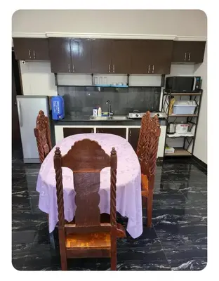 a kitchen with a table with a pink table cloth on it at Kame House in Bacoor