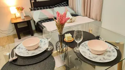 a dining table with two plates and wine glasses at anuva residences room 1 in Manila