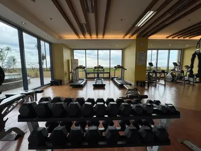 a gym with a bunch of treadmills and chairs at GRAND RIEVERA SUiTES in Manila