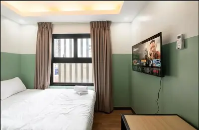 a bedroom with a bed and a flat screen tv at St. Marvin Studio Makati M408 in Manila
