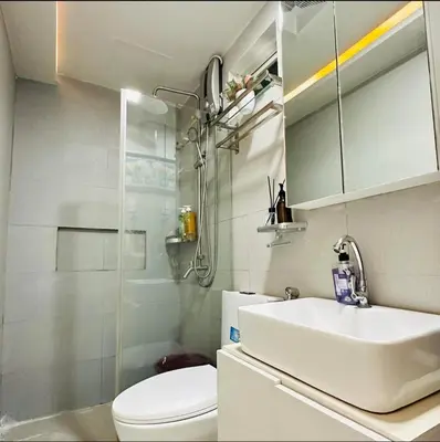 a bathroom with a sink and a toilet and a shower at Cozy Corner Haven near Venice Grand Canal Mall in Manila