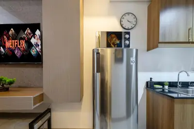 a stainless steel refrigerator in a kitchen with a clock at Lush Residences Makati in Manila