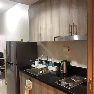 a kitchen with a sink and a refrigerator at S Residence Condo Near MOA,IKEA in Manila
