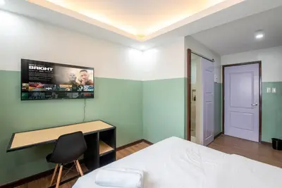 a bedroom with a bed and a desk and a monitor at St. Marvin Studio Makati M407 in Manila