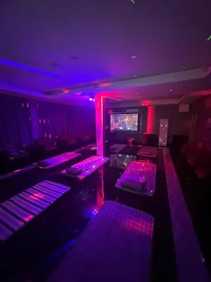a club with purple lights and tables in a room at Jjimjbang hotel spa in Manila