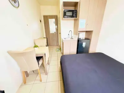 a small room with a table and a kitchen at Modern style Condo with Unli Wifi and Netflix in Manila