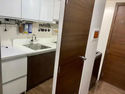a kitchen with a sink and a wooden door at Woodland Elegance Retreat Symphony of Artistry with Blazing fast 300 Mbps in Manila