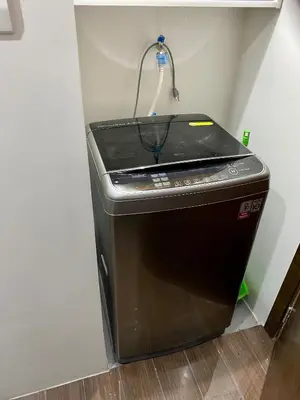 a washer and dryer in a corner of a room at Woodland Elegance Retreat Symphony of Artistry with Blazing fast 300 Mbps in Manila