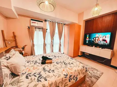 a bedroom with a bed and a flat screen tv at Condo Unit Viceroy Residences Mckinley Hill cd22b in Manila