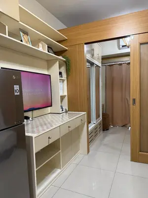 a kitchen with a large tv on the wall at Aiza's CondoTel in Shell Residences near MOA and NAIA in Manila