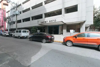 two cars parked in front of a building at RedDoorz at TJMG by Bel Air Polaris Makati in Manila