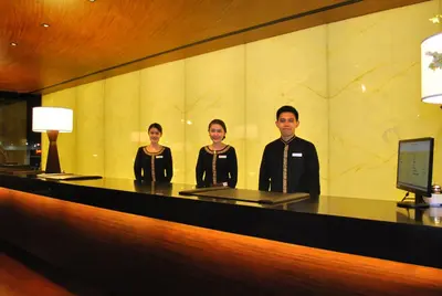 a group of three people standing at a counter at City Garden Grand Hotel in Manila