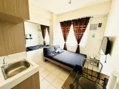 a small room with a bed and a sink at Fancy Condo with Unli Wifi and Netflix in Manila