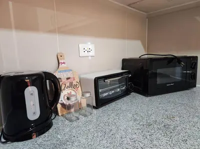 a microwave and a toaster oven in a room at BGC Cosy Spacious 1BR Uptown Parksuites with Balcony in Manila