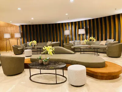 a living room with couches and tables and flowers at Shore Residences MOA Dynastel Staycation in Manila