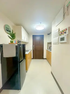a kitchen with a black refrigerator in a room at 1BR BGC Uptown Modern Condo Netflix 200Mb Wifi in Manila