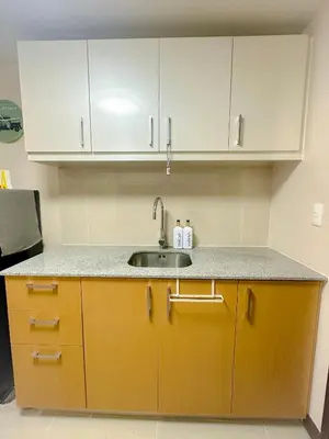 a kitchen with a sink and white cabinets at 1BR BGC Uptown Modern Condo Netflix 200Mb Wifi in Manila