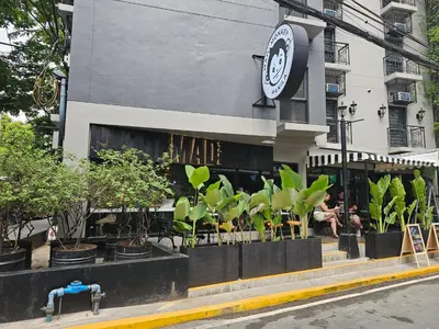 a restaurant with plants in front of a building at Mad Monkey Manila in Manila
