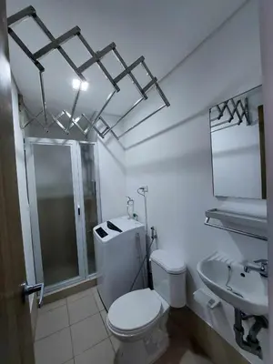 a bathroom with a toilet and a shower and a sink at Sojourn at SMDC Hope Residences in Trece Martires