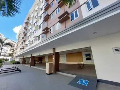 a large building with a parking lot in front of it at Sojourn at SMDC Hope Residences in Trece Martires