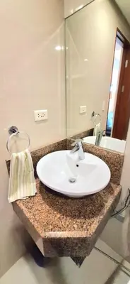a bathroom with a white sink and a mirror at Eastwood LeGrand 3 Cozy & Modern Studio Type Condominium in Manila