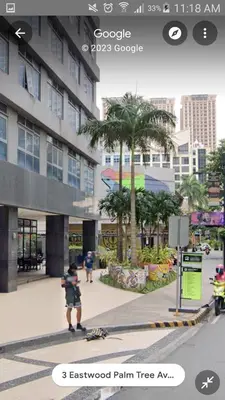 a man riding a skateboard down a city street at Eastwood LeGrand 3 Cozy & Modern Studio Type Condominium in Manila