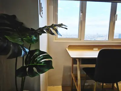 a table and a plant in a room with a window at Stylish and Spacious Studio Unit in Makati with Fast Wi-Fi in Manila