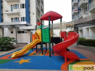 a playground with a slide in front of a building at Ever Stays at Light Residences 1BR in Manila