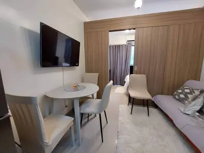 a living room with a table and a tv on the wall at Little Lux Condo Shore 2-T3 Improved in Manila