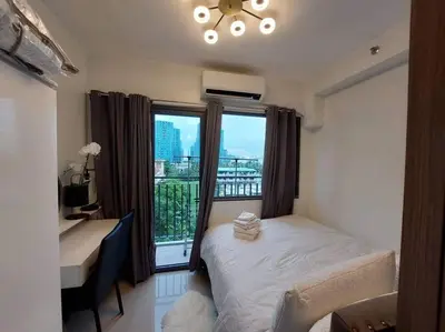 a bedroom with a bed and a desk and a window at Little Lux Condo Shore 2-T3 Improved in Manila