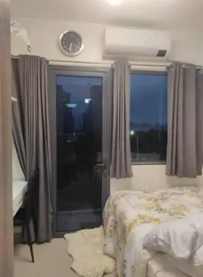 a bedroom with a bed and a window and a clock at Little Lux Condo Shore 2-T3 Improved in Manila
