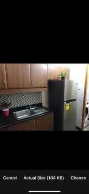 a kitchen with a black refrigerator and a sink at Montecito Luxury 1 bedroom condominium in Manila