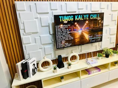 a living room with a tv on a wall at Stylist Luxe Condo near Mall of Asia - Shore 3 in Manila