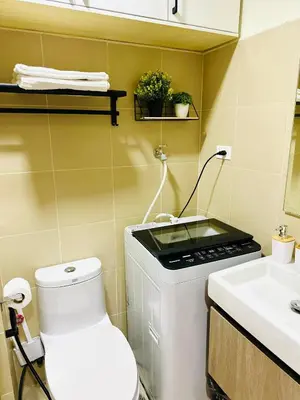 a small bathroom with a toilet and a sink at Stylist Luxe Condo near Mall of Asia - Shore 3 in Manila