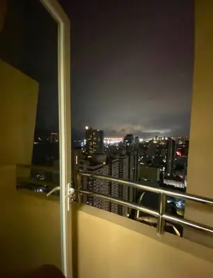 a room with a view of a city at night at FREE Pool n FREE Sauna Access OceanView Balcony in The Heart of Manila, Front of Robinsons Mall, Walking Distance to US Embassy Limited Slots x Secure Your Limited Offer This Month in Manila