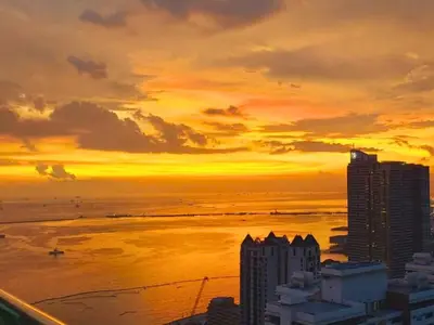 a sunset over the ocean and a city at FREE Pool n FREE Sauna Access OceanView Balcony in The Heart of Manila, Front of Robinsons Mall, Walking Distance to US Embassy Limited Slots x Secure Your Limited Offer This Month in Manila